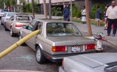 Car with fire hose through window